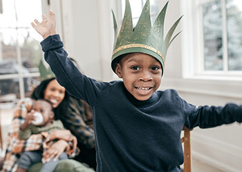 Happy family and a boy with a paper crown hat on